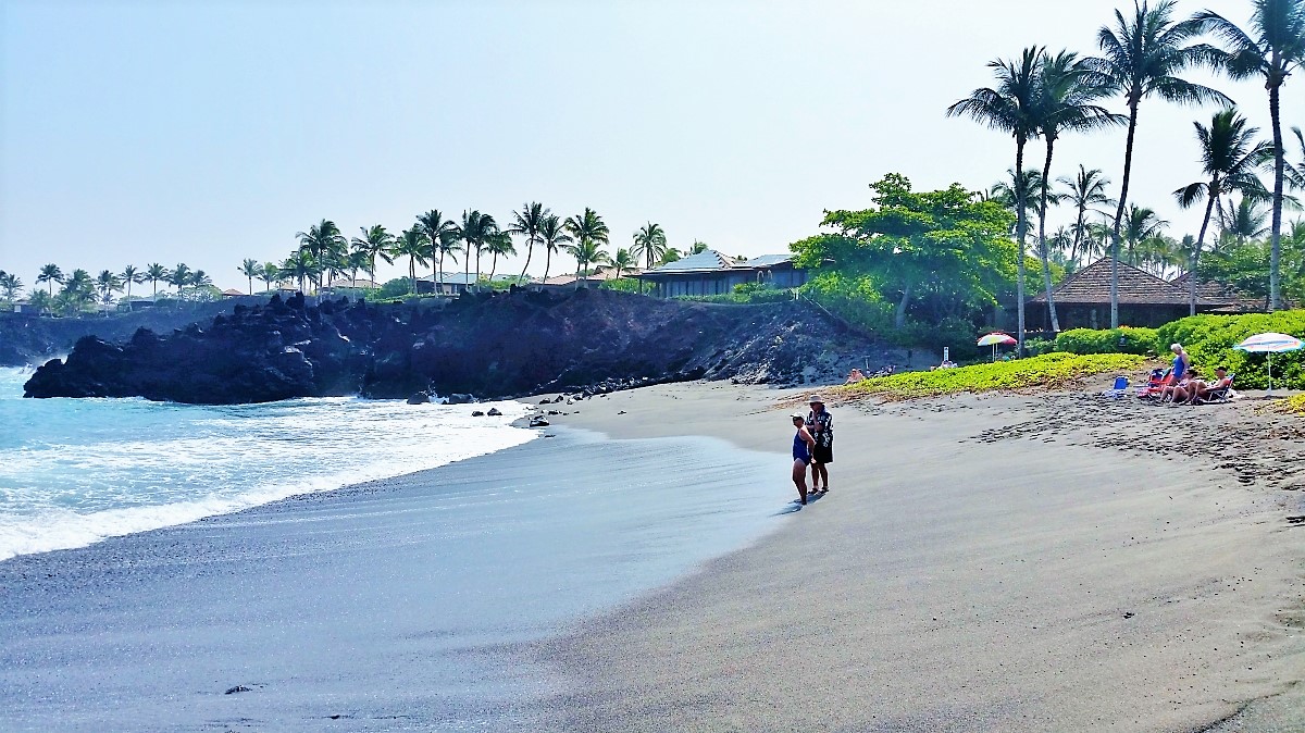 A steep lava rock cliff creates a natural border along Honoka'ope Beach (49 Black Sand Beach)